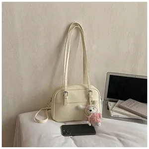 Detail of off-white lychee pattern bag with rabbit pendant and silver hardware