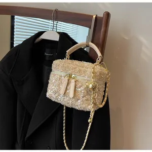 Detail der Tweed-Eimertasche mit champagnerfarbenen Pailletten und Kettenriemen