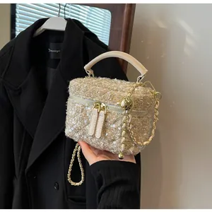 Detailansicht der Tweed-Handtasche mit goldenen Pailletten und Ledergriff mit Kette