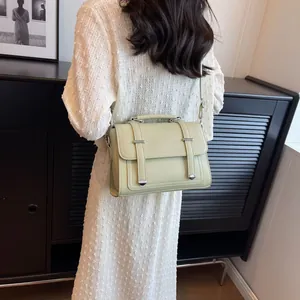 Litchi texture sage green crossbody bag styled with a white textured dress