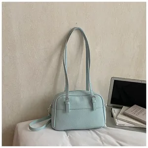 Detailed view of light blue lychee pattern faux leather bag with metal buckle straps