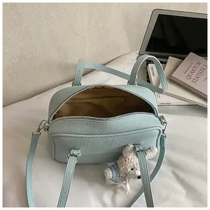 Macro view of light blue lychee pattern bag showing interior lining and rabbit charm