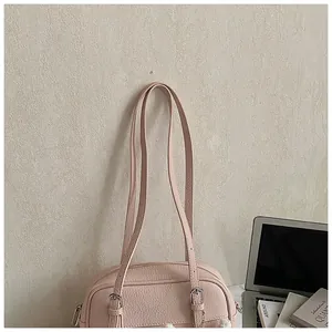 Detailed view of pale pink lychee pattern leather shoulder bag with silver buckles