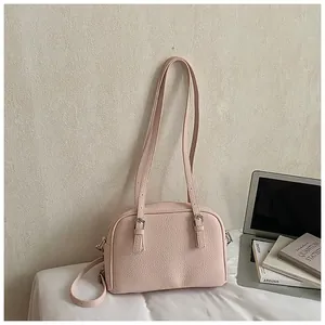 Detail of pink lychee pattern leather handbag with silver hardware and dual straps