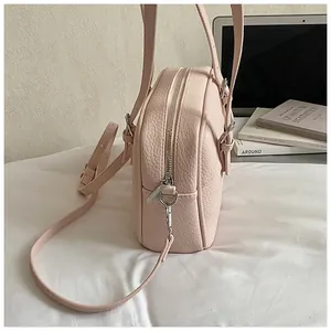 Detail view of pink lychee texture leather shoulder bag with silver metal zippers