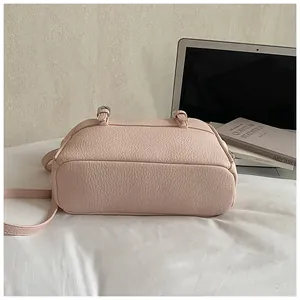 Macro detail of nude pink pebble leather texture and silver buckle on crossbody bag