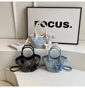 Détail de sacs seaux à carreaux avec logo métallique et pendentifs chien en divers coloris