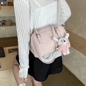 Pink lychee grain leather crossbody bag with cute white rabbit plush charm for women