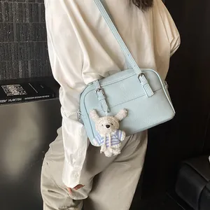 Light blue lychee pattern shoulder bag with cute teddy bear charm on model view