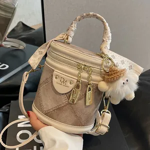 Sac seau beige et marron avec texture matelassée, poignée foulard et breloque en peluche