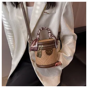 Detail of vintage monogram barrel bag with silk scarf handle and gold hardware detail