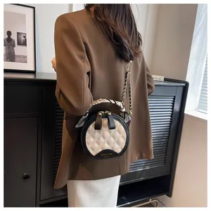 Détail du sac à main rond matelassé avec poignée en soie et chaîne dorée
