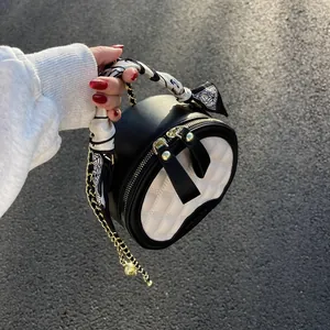 Sac à main rond matelassé noir et blanc avec chaîne dorée et poignée en soie