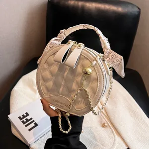 Sac rond matelassé beige avec poignée foulard en soie et bandoulière en chaîne dorée