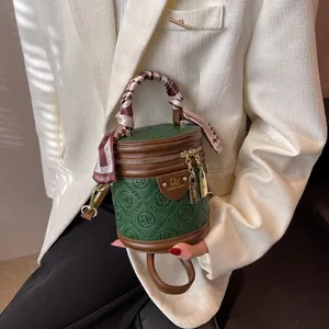 Retro forest green and brown round crossbody bag with logo embossing and silk scarf wrap