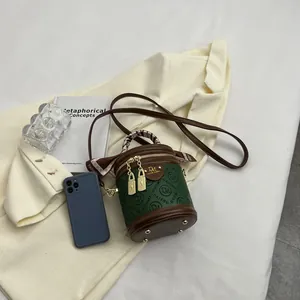 Vintage green cylindrical crossbody bag with silk scarf handle and dual gold zippers