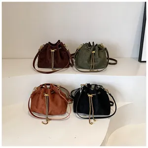 Close-up of four colored drawstring bucket bags with golden metal ball chains
