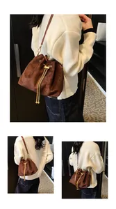 Detail of dark brown faux suede bucket bag with gold chain drawstring and shoulder strap