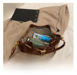 Internal view of the brown matte bucket bag with golden chain and zipper pocket