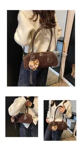 Detailed view of coffee suede bowling bag featuring a plush leopard heart pendant