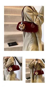 Detail of burgundy matte shoulder bag with leopard heart charm on a trench coat outfit