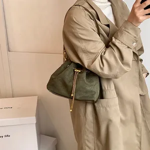 Chic dark green suede drawstring bucket bag with gold chain and brown base detail