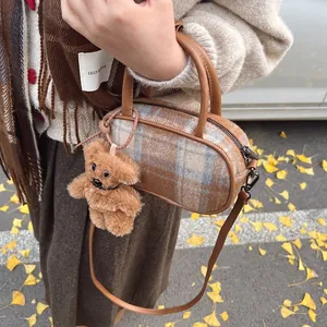 Sac bowling à carreaux en laine marron sur fond de feuilles de ginkgo d'automne