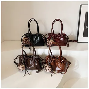 Détail de sacs à main vintage plissés en quatre couleurs avec charm léopard