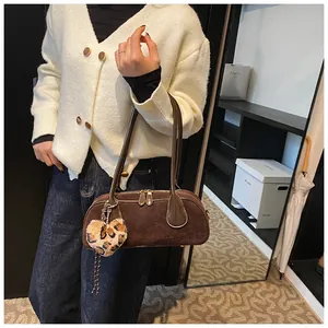 Detail of a brown matte texture bowling bag with a trendy leopard heart pendant accessory
