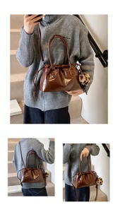 Détail d'un sac à main marron brillant avec cordon de serrage plissé et pompon léopard