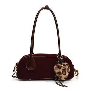 Deep red velvet underarm shoulder bag with long leather handles and leopard heart charm