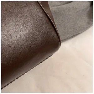 Primer plano de la textura de cuero marrón oscuro y costuras en la esquina del bolso tote