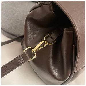 Detalle de hebilla dorada y conexión de correa en bolso tote de cuero suave marrón