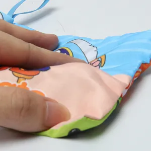 Détail macro d'un livre en tissu rembourré avec des imprimés colorés et un cordon