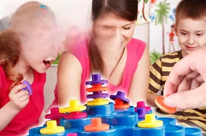 Kids playing with colorful balanced stacking tower toy set for motor skills development