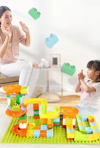 Close-up of colorful large building blocks with slides and balls on a green baseplate