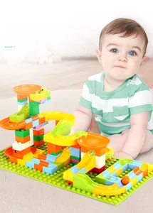 Close-up of colorful marble run blocks with slide tracks and funnels on a green baseplate