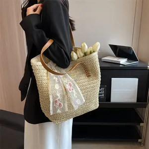 Detail of a large straw tote bag with floral lace scarf and brown leather handles