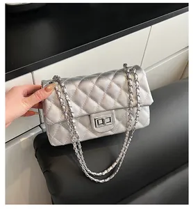Close-up of silver quilted crossbody bag with metallic finish and metal chain strap