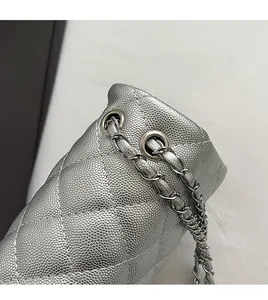 Detail of silver quilted leather bag with metallic chain strap and polished eyelets