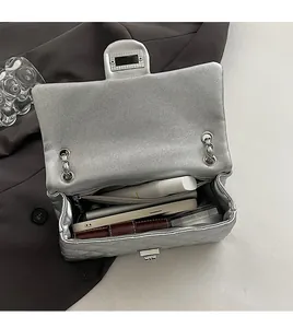Detail view of the spacious inner compartment and silver quilted texture of the chain bag