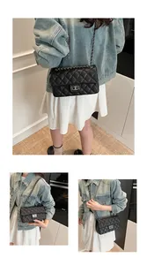 Detail of a black quilted chain bag featuring a silver rectangular turn-lock and leather strap