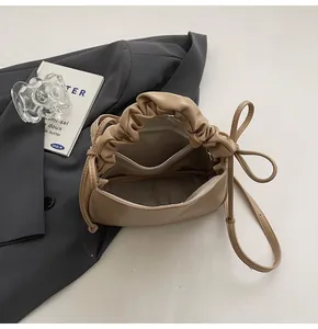 Detailansicht der beigen Raffgriff-Handtasche mit Hauptfach und praktischer Innentasche