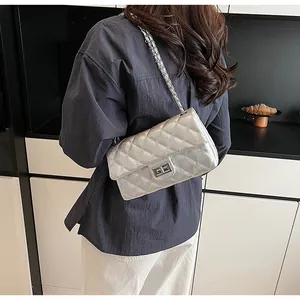 Silver quilted chain bag with metallic finish and turn-lock shown on a shoulder