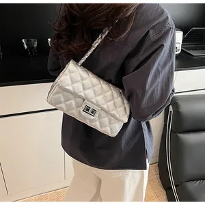 Detail of silver quilted chain bag featuring metallic texture and turn-lock closure