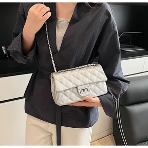 Detail of silver quilted crossbody bag with metal chain strap and turn-lock closure