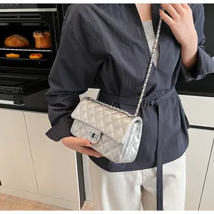 Detail of silver quilted leather chain strap bag with rectangular metal turn-lock closure