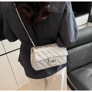 Close-up of a silver quilted chain bag with a metallic finish and a classic turn-lock