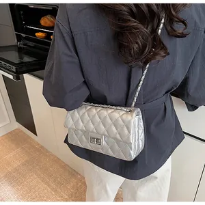 Rear view of a model wearing a silver quilted chain strap crossbody bag in a kitchen