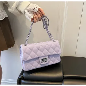 Detail of lavender quilted crossbody bag with silver metal lock and chain strap